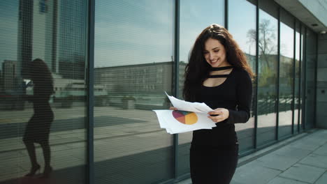 mujer empresaria de primer plano caminando por la calle. mujer leyendo documentos al aire libre