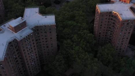 aerial footage pans up from housing projects of harlem to reveal part of the new york city skyline at sunrise golden hour