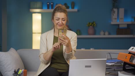 trabajadora de oficina en casa hablando por teléfono en facetime feliz.