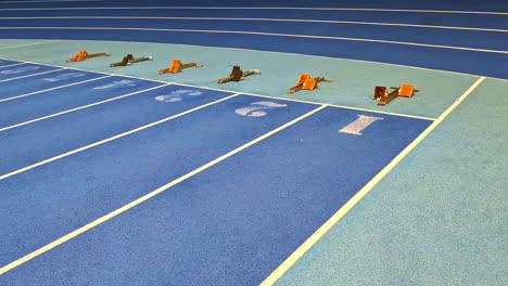 empty blue running track with starting blocks lined up in each lane