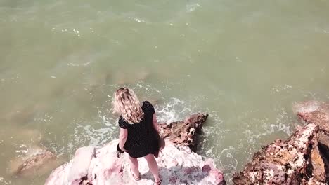woman standing on cliff edge admiring stunning ocean water darwin