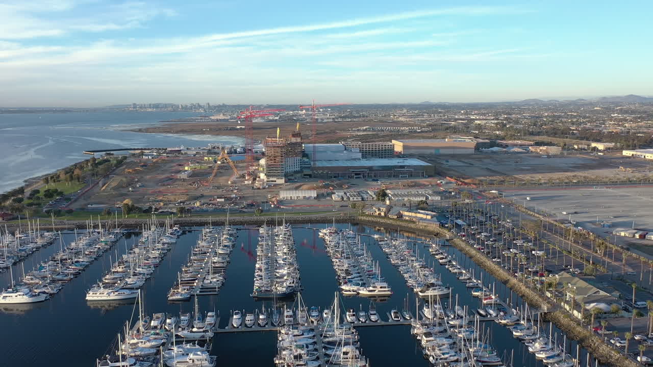el nuevo centro de convenciones que se está construyendo en chula vista, california, con el horizonte de san diego en la distancia, la marina con barcos en primer plano
