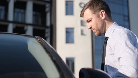 businessman puts on a tie on the street looking out the window of his car businessman puts on a tie on the street looking out the window of his car unpunctual man being late for a meeting