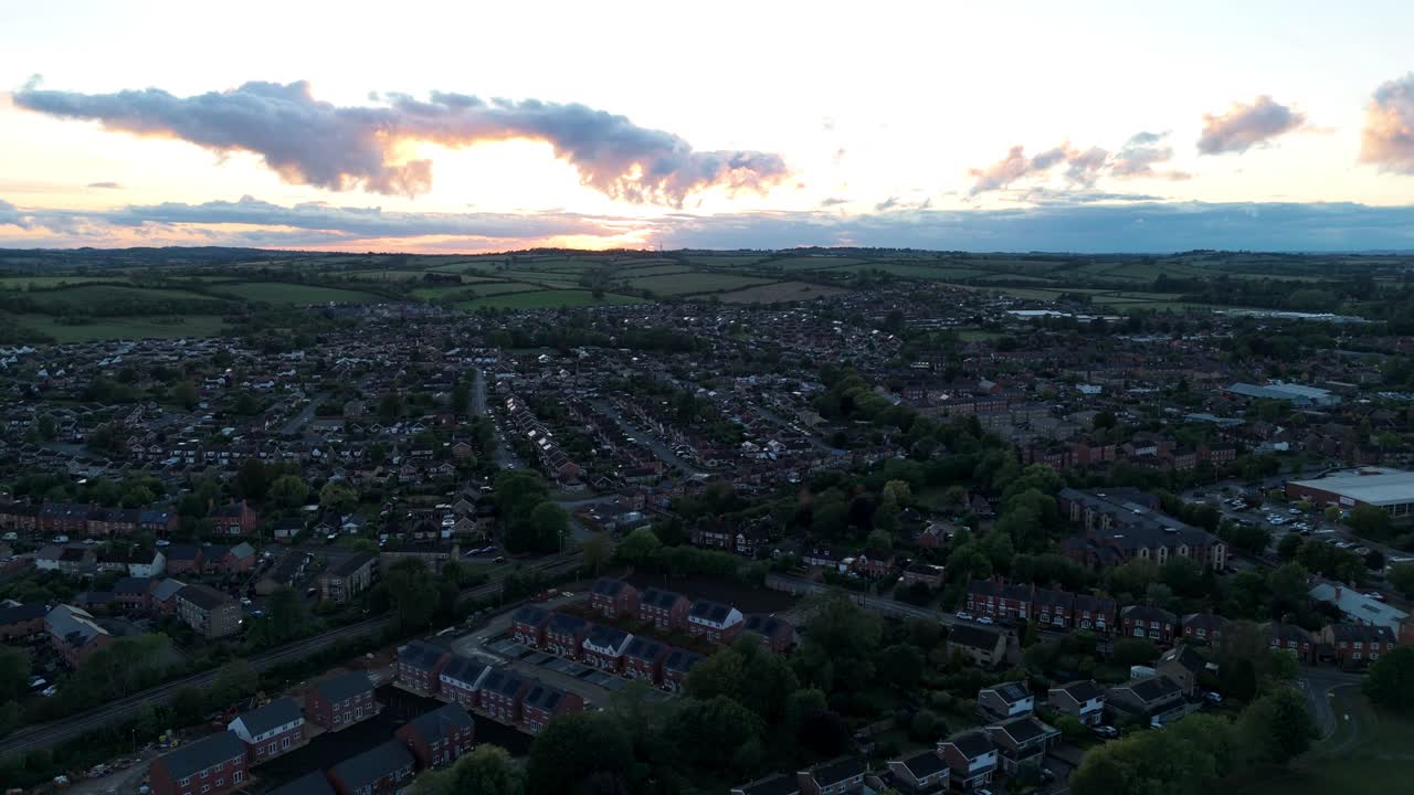 Aerial drone view of Oakham Town in Rutland at summer sunset with golden light over rooftops, countryside, and historic buildings in England