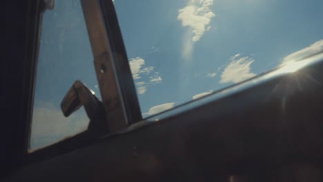 ventana abierta del coche con cielo soleado