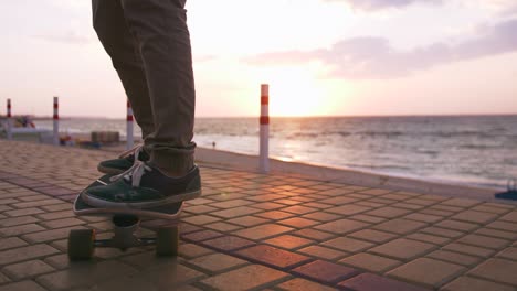 close up shot of young man skateboarding on the road near the sea, slow motion