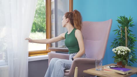 happy woman looks out the window and takes a deep breath.