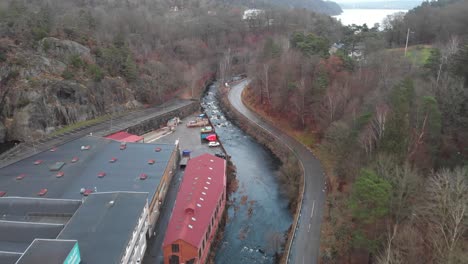 Aerial-View-of-a-river-near-a-building-in-Jonsered-Sweden,-pullback-shot