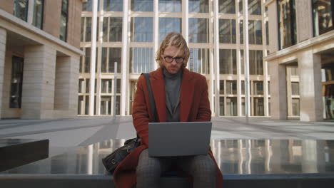 Portrait-of-Young-Confident-Businessman-with-Laptop-Outdoors