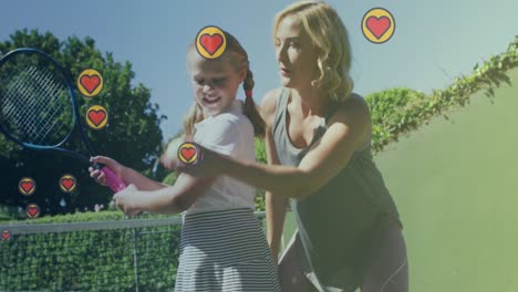 Animation-of-heart-icons-over-caucasian-mother-with-daughter-playing-tennis
