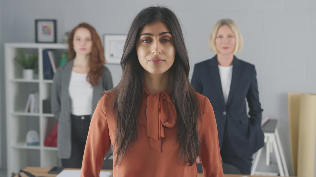 retrato de una mujer seria equipo de negocios multirracial de pie en la oficina
