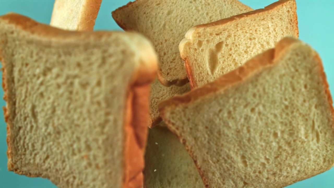 White Bread Slices Falling in Slow Motion on Blue Background
