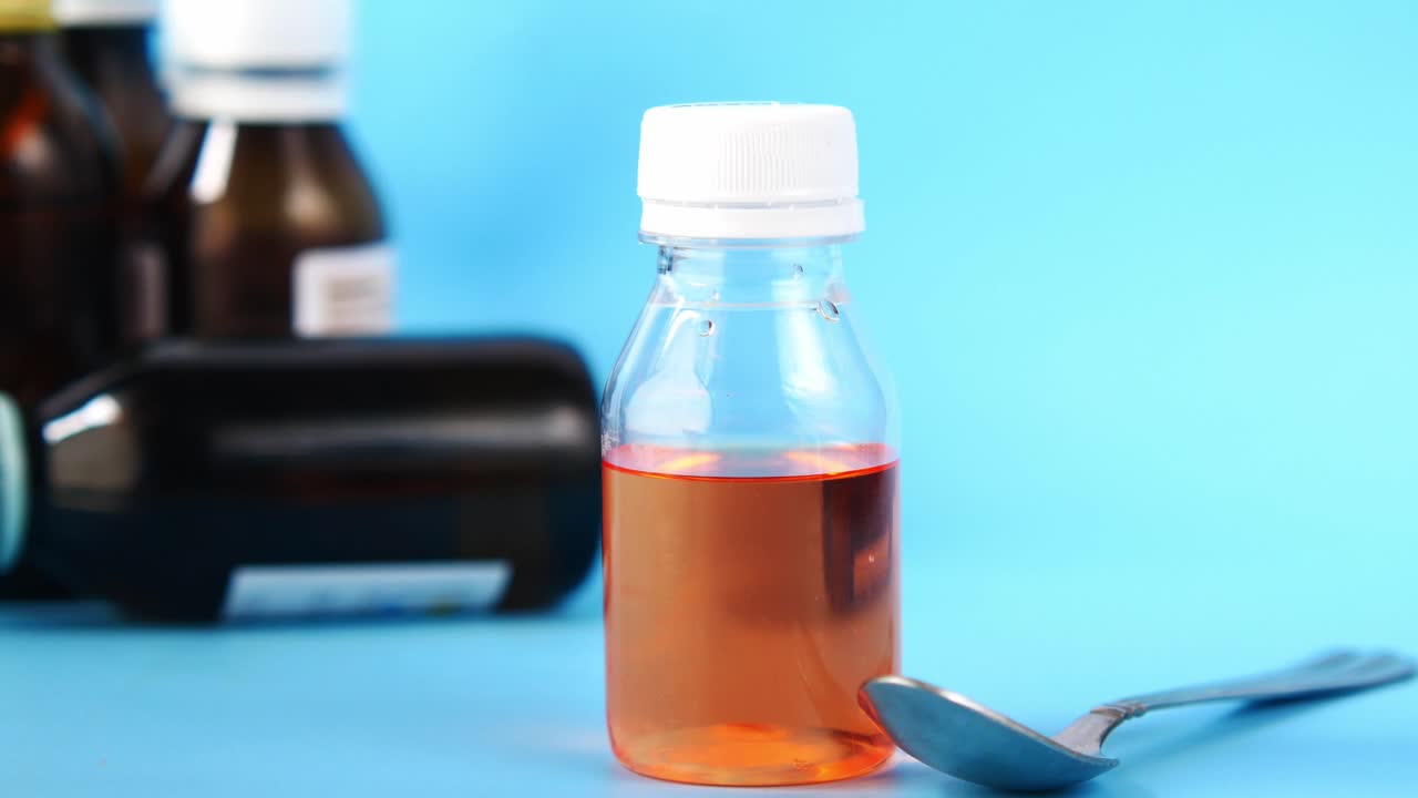 Liquid medicine in a small bottle with a spoon
