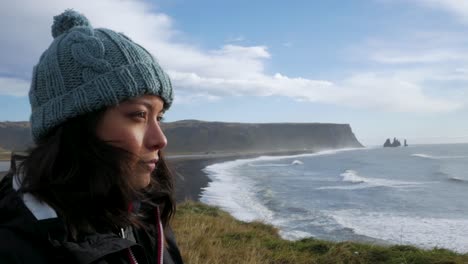 close up of woman with ocean cliff backdrop