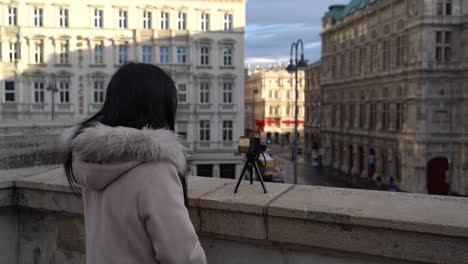 Mujer-Turista-Sola-Usando-Una-Cámara-Pequeña-En-Un-Trípode-Para-Filmar-El-Paisaje-De-La-Ciudad