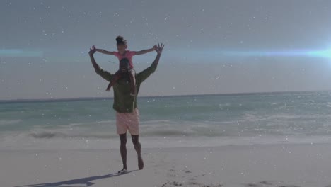 animación de rastros de luz sobre un hombre afroamericano y su hija jugando juntos en la playa