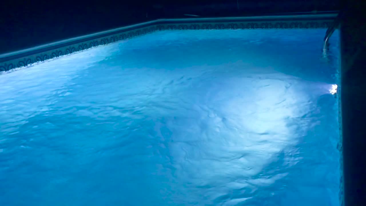 Vacant due to Covid-19 relaxing night swimming pool with led lights in slow motion