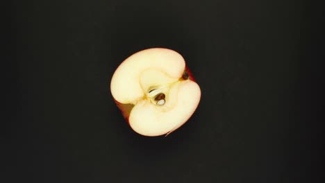 rotating apple on a black background. fresh juices, fruits, vitamin and summer concept. top view of half a juicy apple