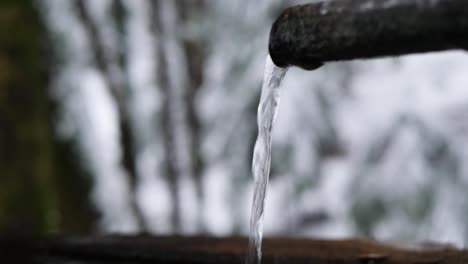 Fountain-pipe-in-a-snowy-forest-in-Switzerland