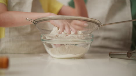 kids sifting flour for baking