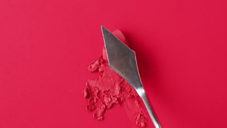 red lipstick swatches with spatula