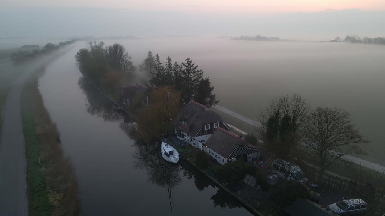 Nebliger Kanal mit Haus von oben, Parrega, Niederlande