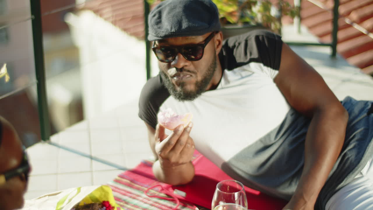 donut de degustación gay barbudo en una cita romántica en la terraza de la azotea