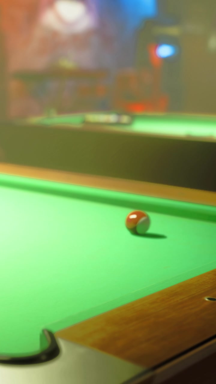 Pool ball rolls on green table in a recreational room during evening hours