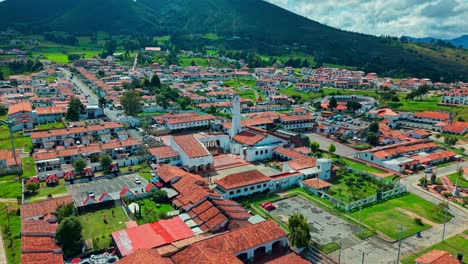 sweeping pan over guatavita, colombia, showing red rooftops and scenic mountain landscape.