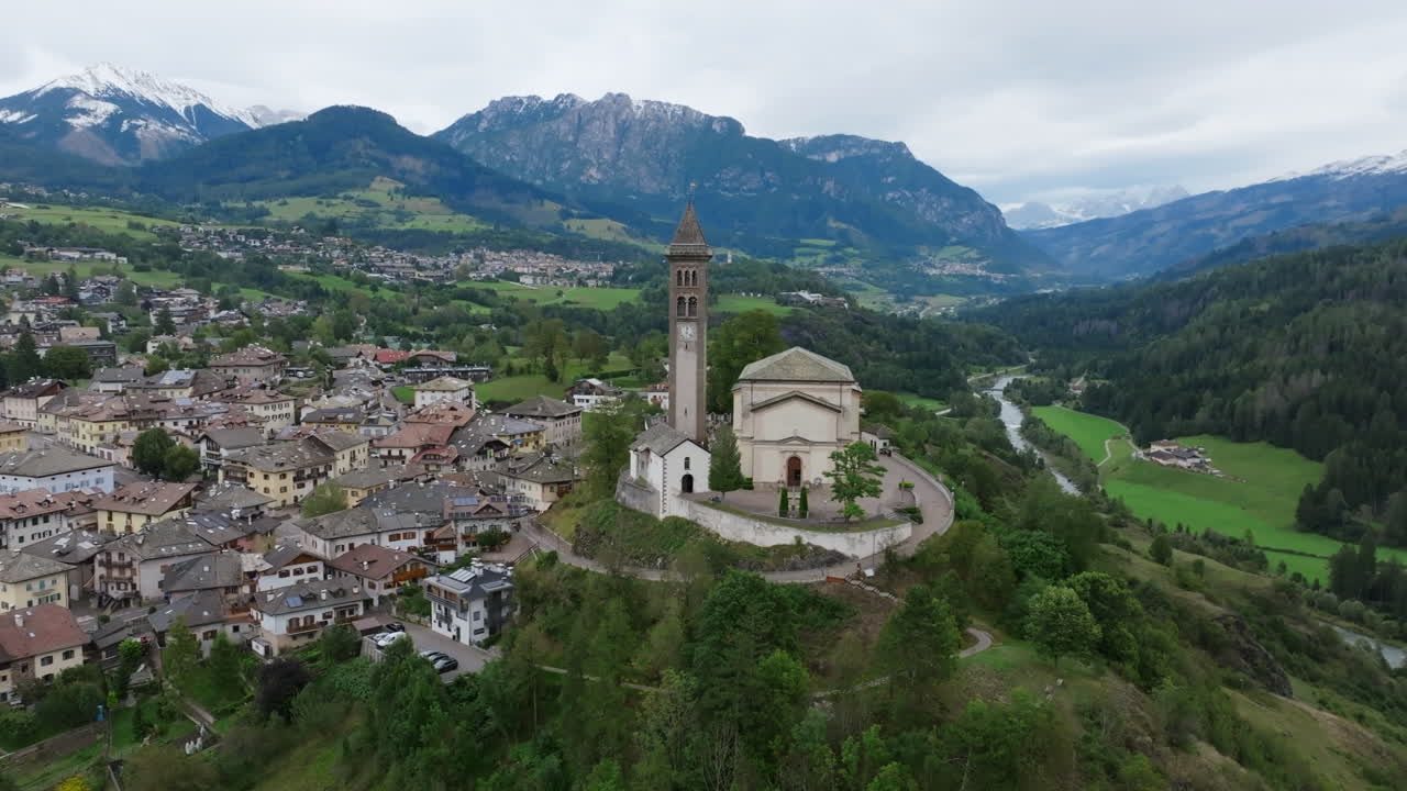 Aerial footage of the town Castello-Molina di Fiemme in Italy closely rotating around the Chiesa di San Giorgio Church.