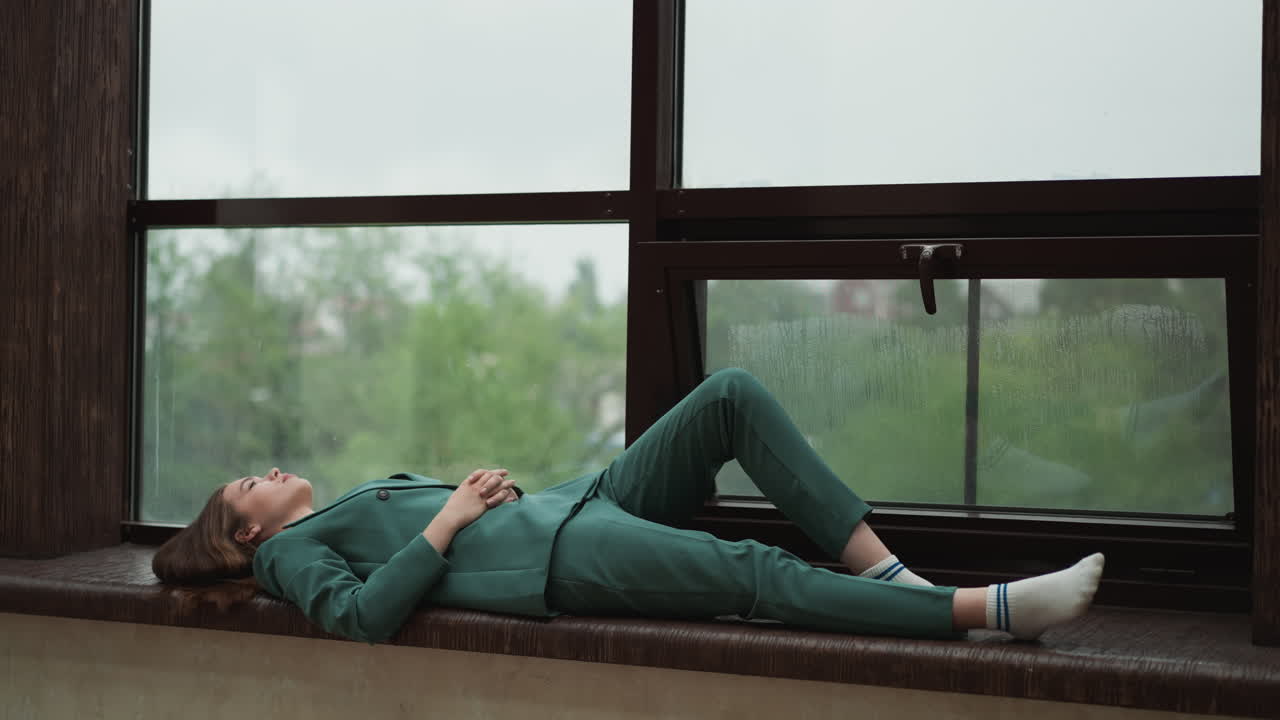 Weary executive collapsed on windowsill. Woman drained from relentless demands of corporate world. Repercussions of relentless overwork in office