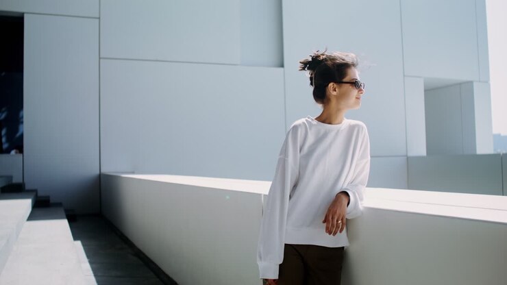 Donna con maglione bianco in architettura moderna