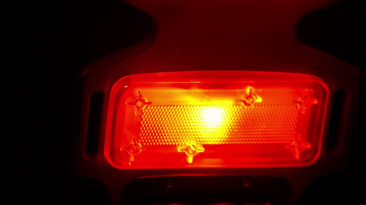 un dispositivo de terapia de luz infrarroja y roja cercana brilla y se mueve cerca de la cámara en una habitación oscura