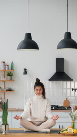 woman meditating in a kitchen