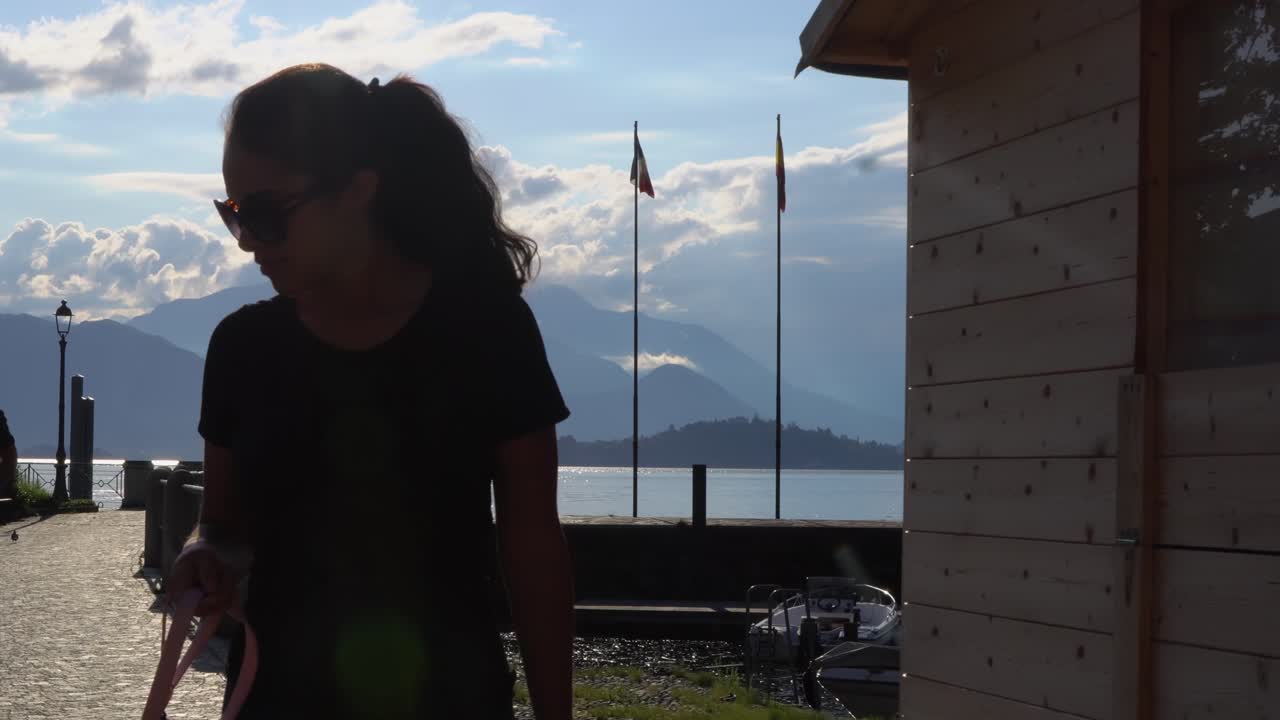 retrato de una mujer joven caminando con su perro en la ciudad costera de laveno mombello en varese, italia