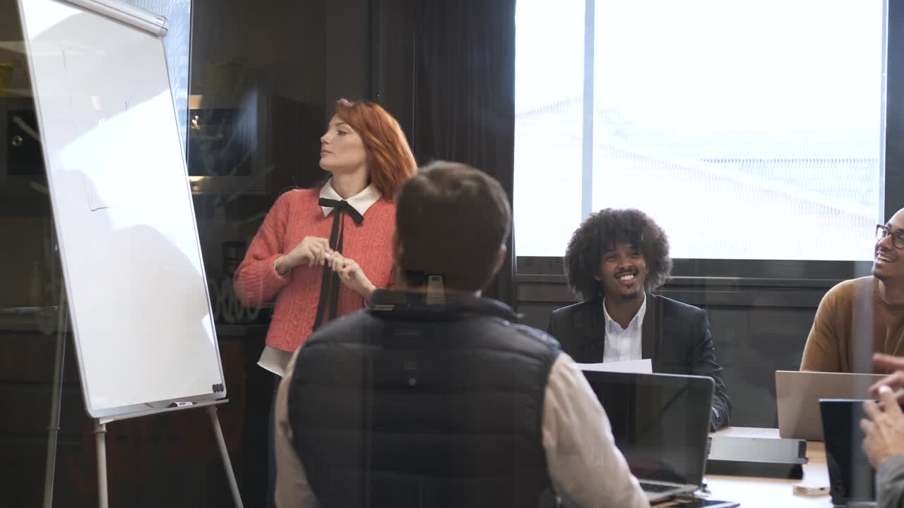 Businesswoman giving presentation to diverse colleagues in conference room