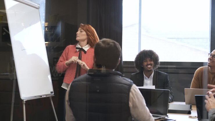 Donna d'affari che tiene una presentazione a colleghi diversi in sala conferenze