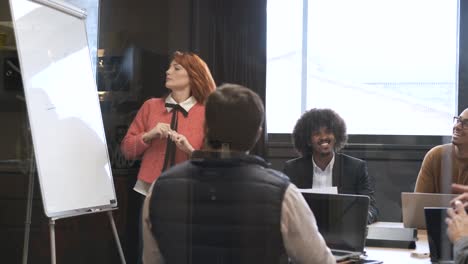 businesswoman giving presentation to diverse colleagues in conference room
