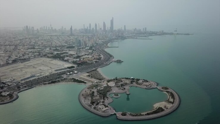 Vista panoramica dello skyline di Kuwait City. Cielo coperto. Ripresa con drone all'indietro