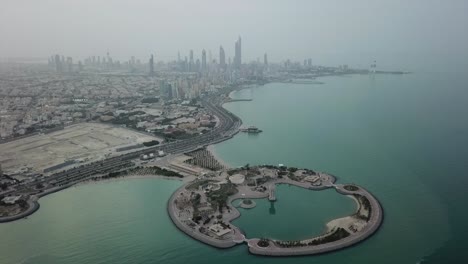 panoramic view of kuwait city skyline. overcast. backward drone shot