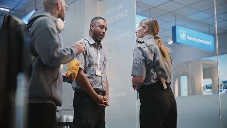 Airport Security Personnel Discussing with Passengers