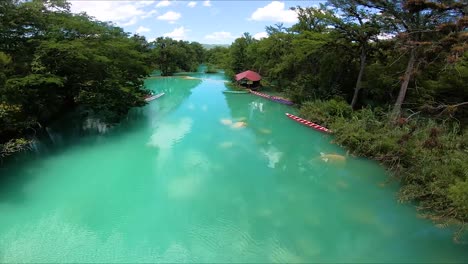 aerial view of turquoise river in lush tropical forest