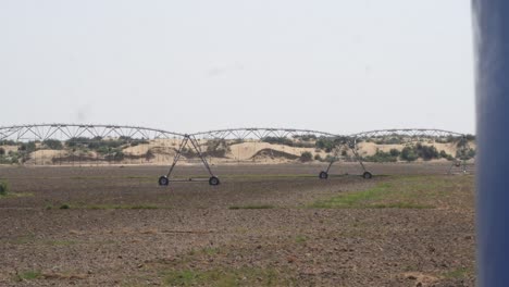 pan left reveal view of center pivot irrigation sprinkler system on farmland in punjab