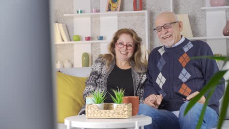 La-Pareja-De-Ancianos-Que-Mira-Televisión-Está-Feliz.