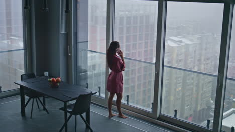 housewife having phone conversation in panoramic luxury flat high angle view