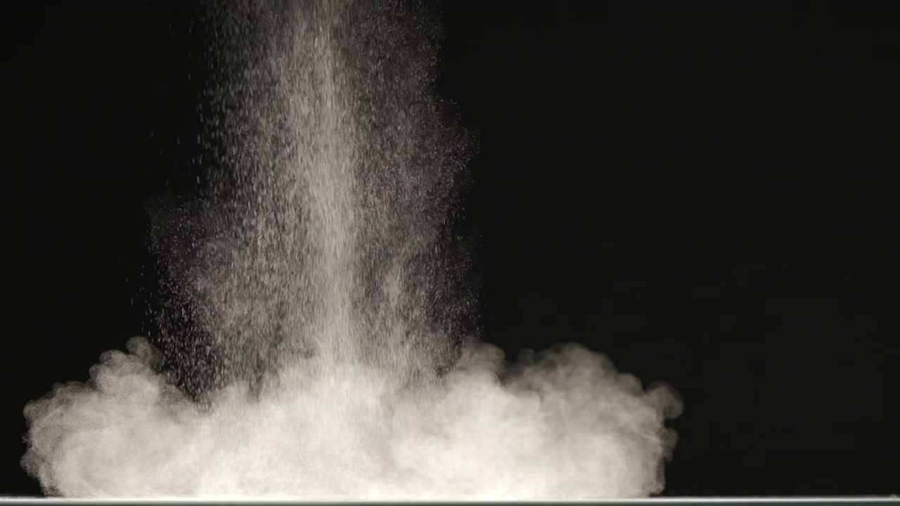 The stream of particles on the black background. slow motion