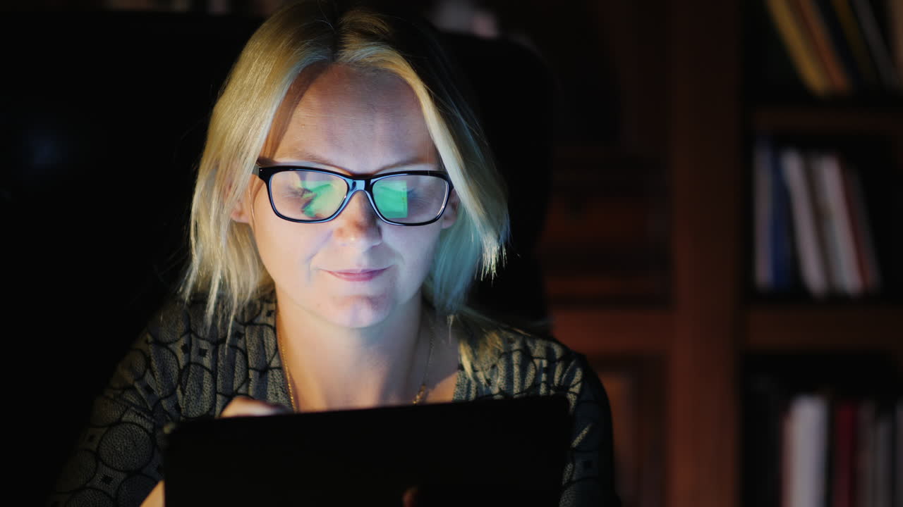 Woman Working on Tablet at Night