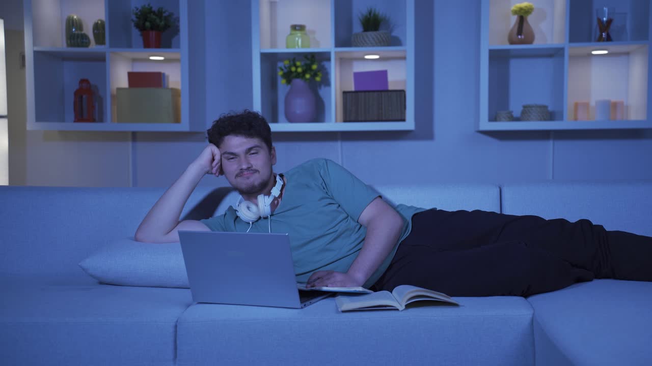 남성 학생은 집에서 밤의 행복한 추억을 기억하고 웃고 있습니다.