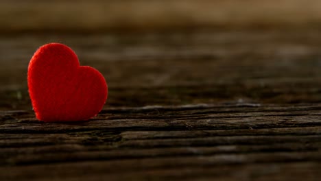 corazón rojo metido en la tabla de madera 4k