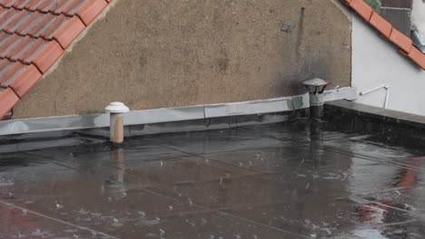 close shot of a roof deck in a suburban neighborhood during hard rain fall